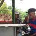 An old man drinking tea at a warung